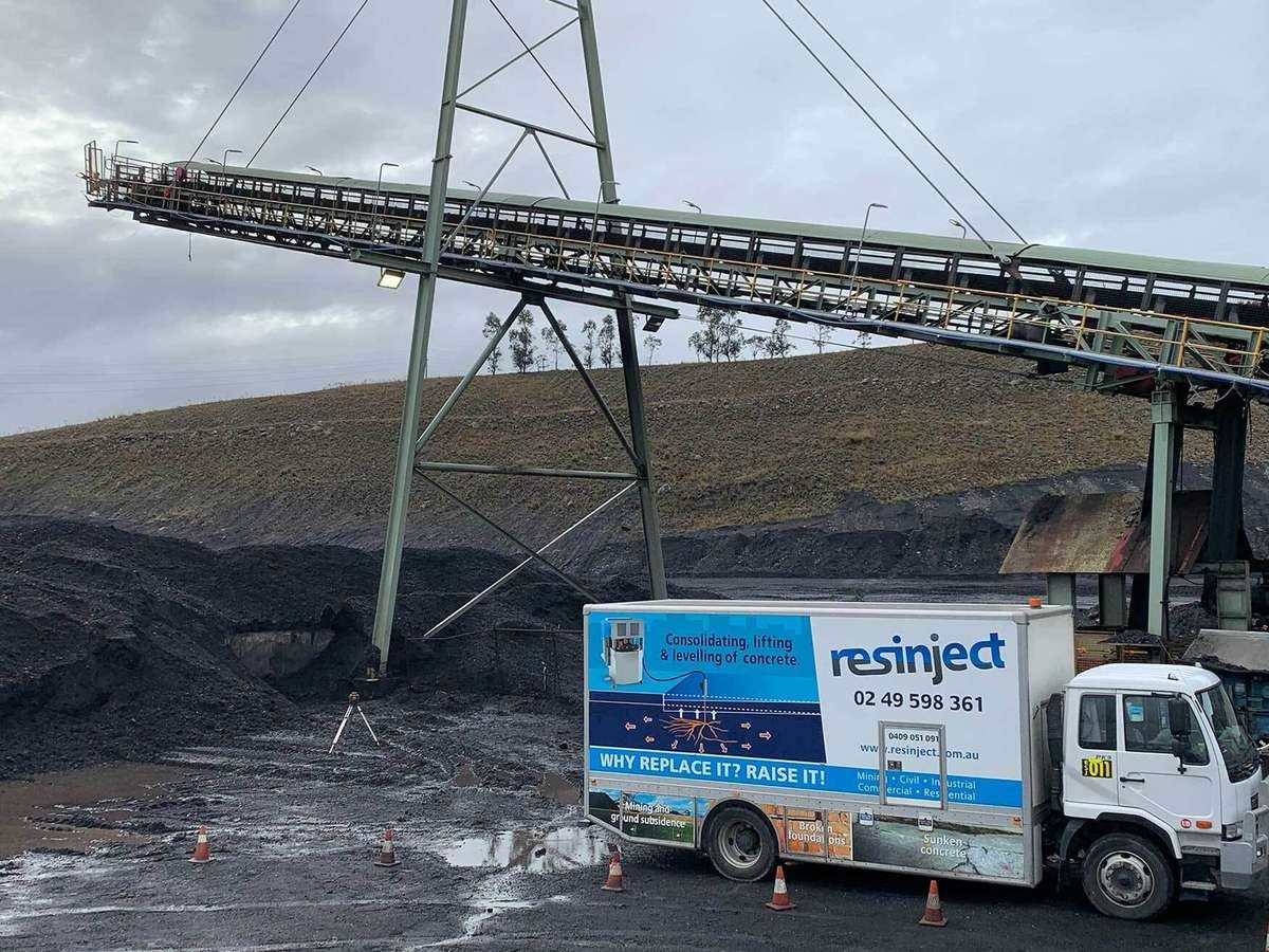 Resinject truck working beneath a mine site conveyor
